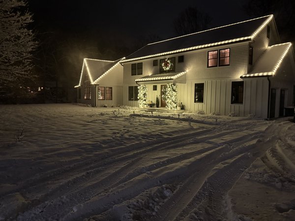 Warm white roofline lighting after a snowfall
